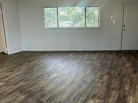 Spacious open living and dining area with a large window overlooking the courtyard bright, airy, and full of natural light.