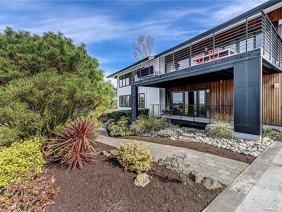 View from the driveway of the 2 decks for relaxation and entertainment, with a walking path leading to the backyard
