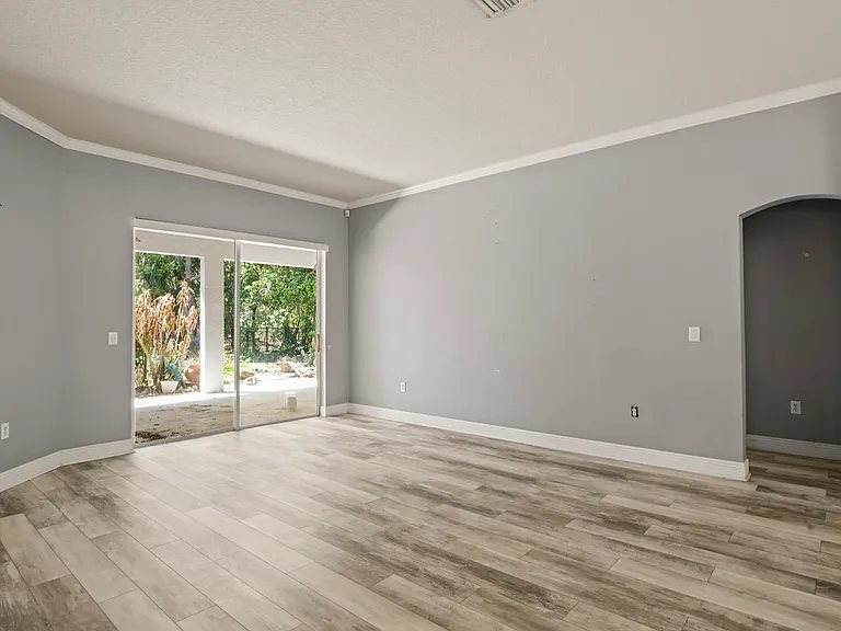 Living area - view of covered lanai and hall to primary bedrom