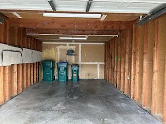 Detached oversized 1-car garage with individual trash bins