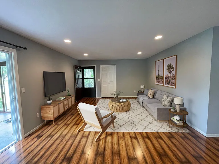 Living room with screen door entrance and 3-season patio to the left. Dining & kitchen to the right.