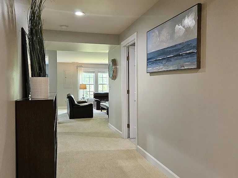 View of the extra wide hallway to family room from bedroom wing. Twin bedroom one on right.