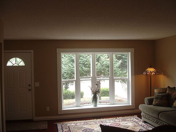 The living room has a large bay window that floods the room with light.