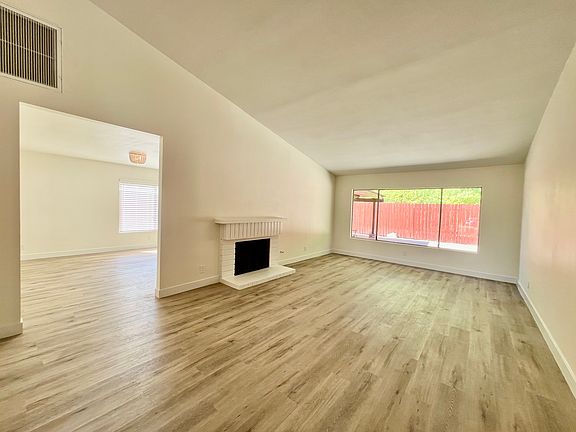 A beautifully refreshed living room with a bright, modern vibe! The walls feature new paint that complements the fresh flooring,