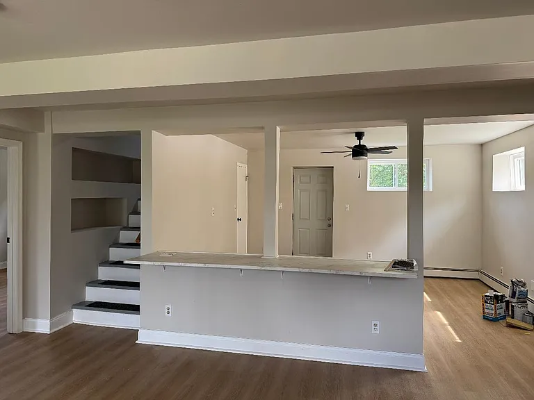 View from kitchen area, counter top eating area and stairway to 2nd level