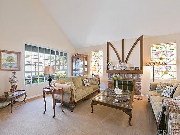 Soaking with natural sunlight and adorned by charming stained glass windows is the living room with a cozy fireplace.