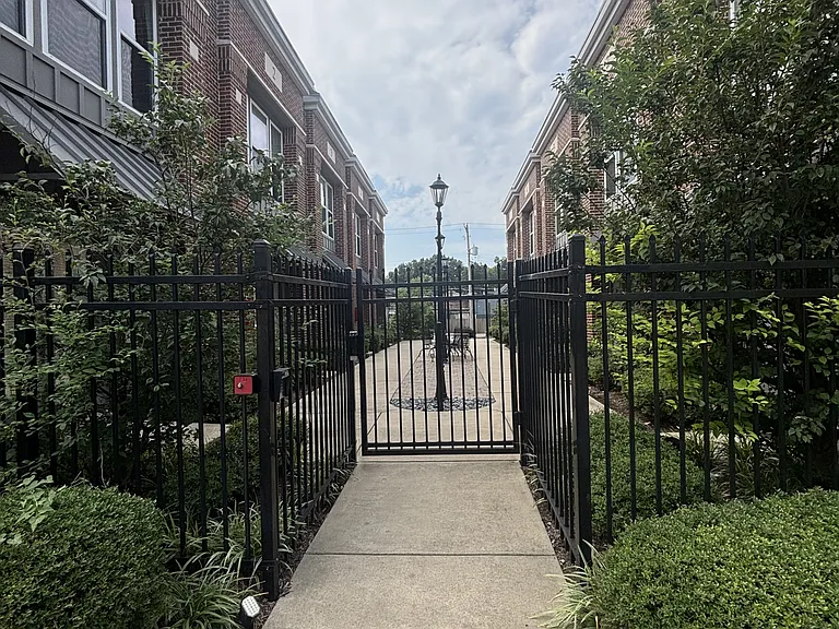 Sidewalk view looking into the courtyard, gate access