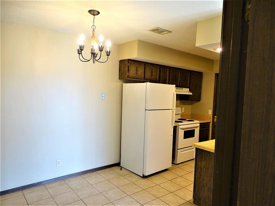 Kitchen has ceramic tile, refrigerator, stove and dishwasher on other side plus dining area.