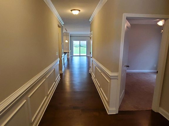 Front Entry with paneling detail. Two bedrooms and shared bath to the right.