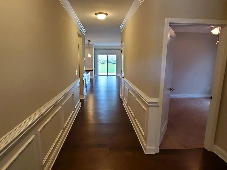 Front Entry with paneling detail. Two bedrooms and shared bath to the right.