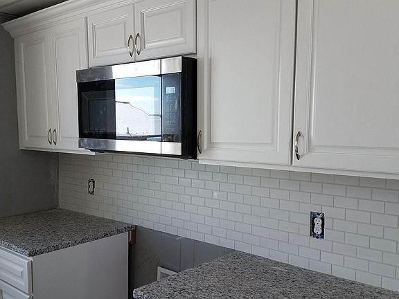 Kitchen displaying stainless steel microhood. Stainless gas 