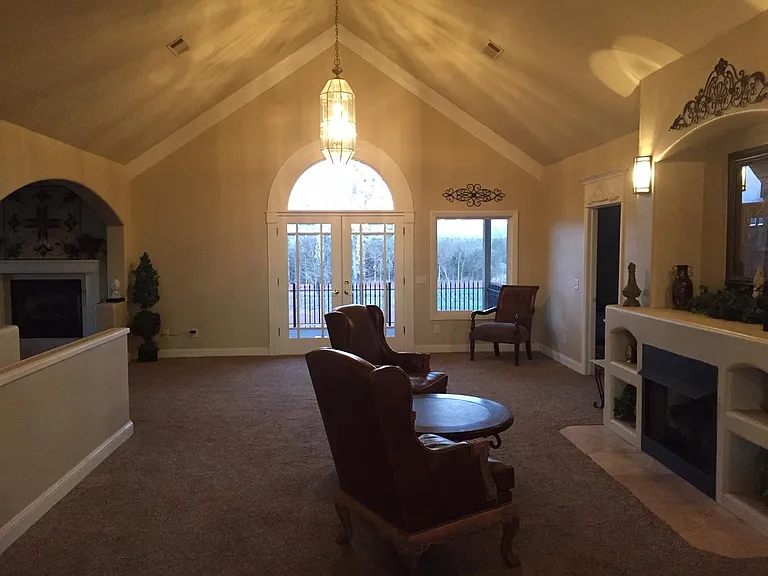 Great room with vaulted ceilings, fire place, and walk-out balcony.