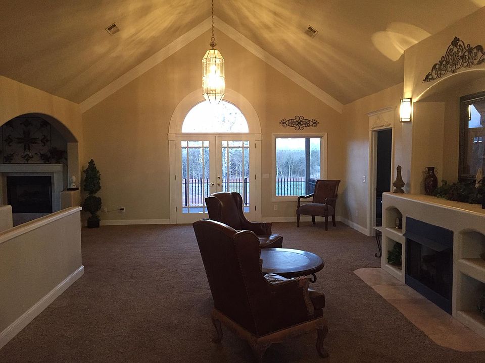 Great room with vaulted ceilings, fire place, and walk-out balcony.