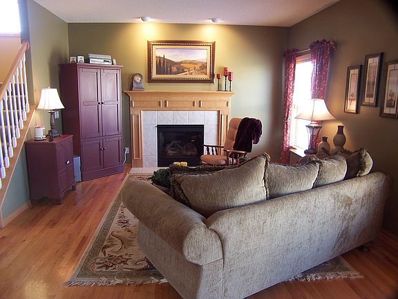 Main level living room with fireplace is open to Kitchen with hardwood floors.