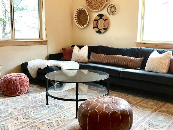 Spacious living area with high ceilings and bright windows.