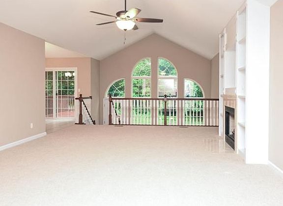 Vaulted atrium great room is light and bright with gas fireplace and built in shelving.