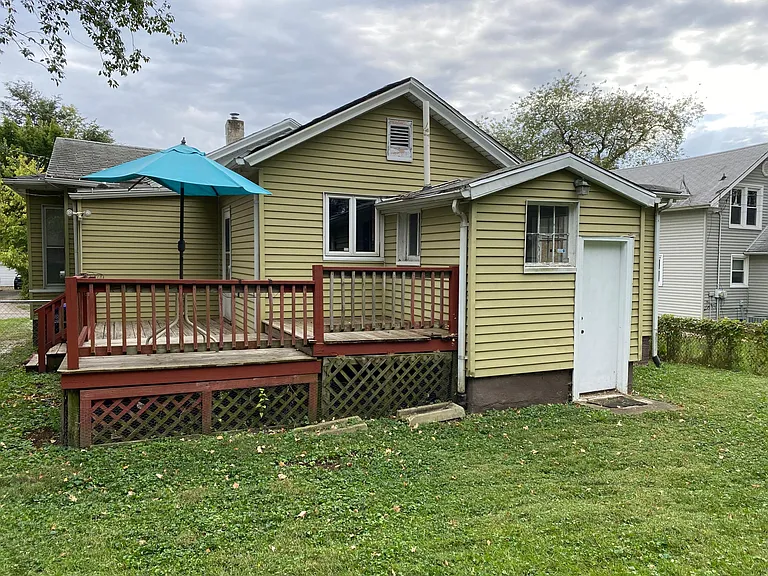 Back view of the three-tiered deck, kitchen window, mud room windows, and the basement door.