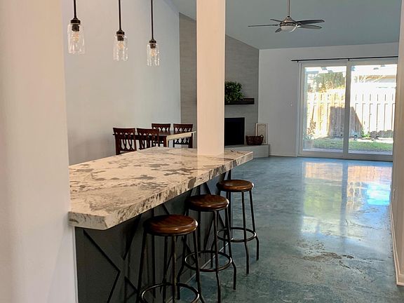 open concept connects the kitchen and living room for an expansive feel. vaulted ceilings with windows bring in the natural light. blue stained concrete floor is low maintenance and durable. kids, pets, no problem!