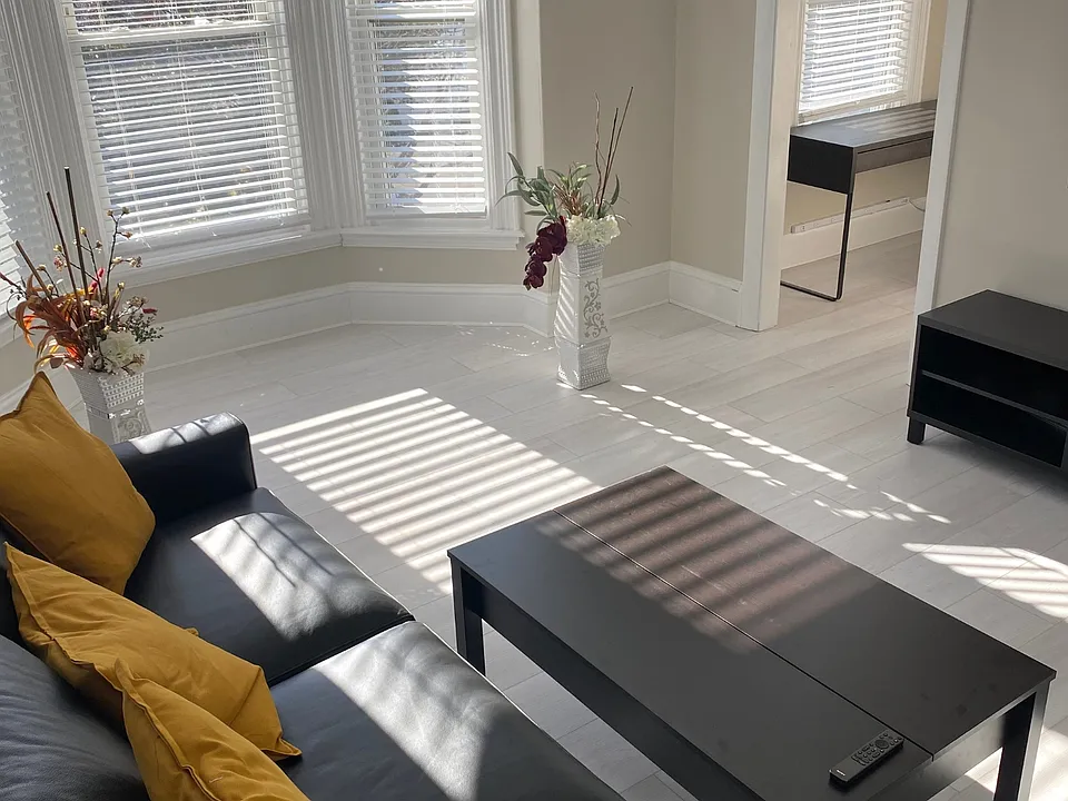 A furnished living room showcasing a cozy, well-proportioned layout, filled with natural light for most of the day and thoughtfully connected to the office/den.