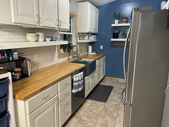 kitchen with butcher block counters, stainless steel appliances and deep farmhouse sink