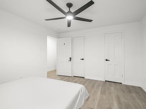 Standard room w/ queen bed, writing table, ceiling fan.