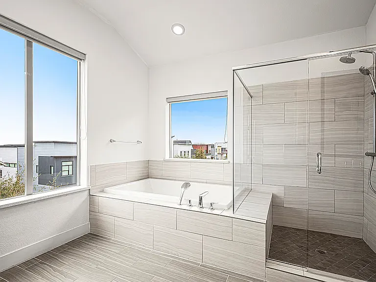 The luxurious primary bath includes a soaking tub, oversized walk-in shower, and generous counter space for a true spa-like experience