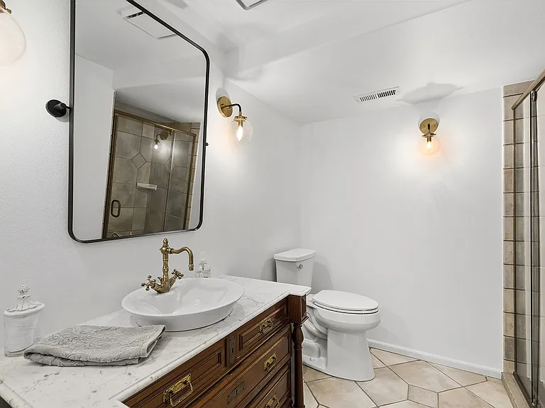 Hall Bathroom with step in shower (directly adjacent to bedroom 4). This bath also serves the Bonus/media.