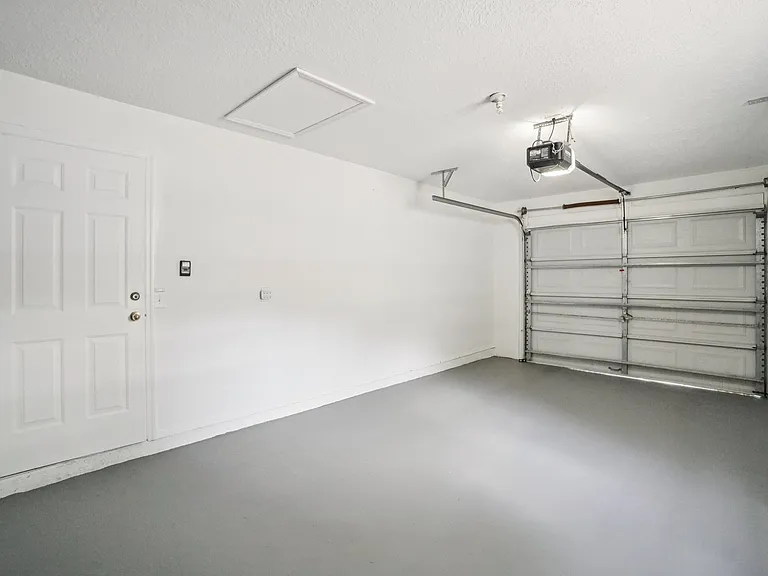 Attached 1-car garage with a premium high-gloss floor to be used as a clean storage area, home gym, or play space