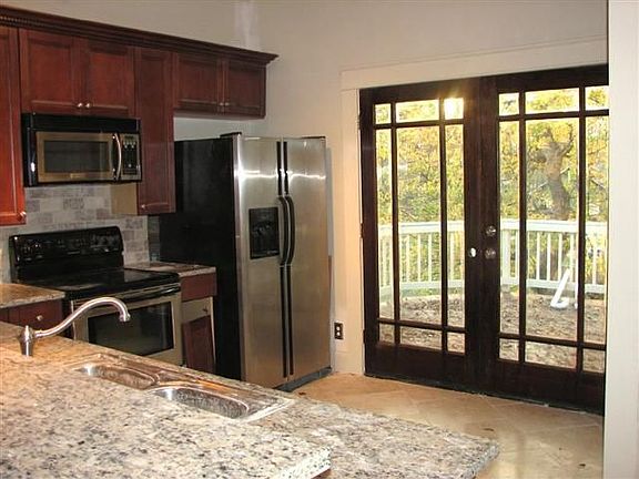 Kitchen with granite, stainless, pantry & travertine floors.