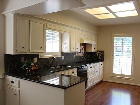 Delightful kitchen with granite counters and tiled backsplash. Large shuttered windows and gleaming wood floors are very desirable.
