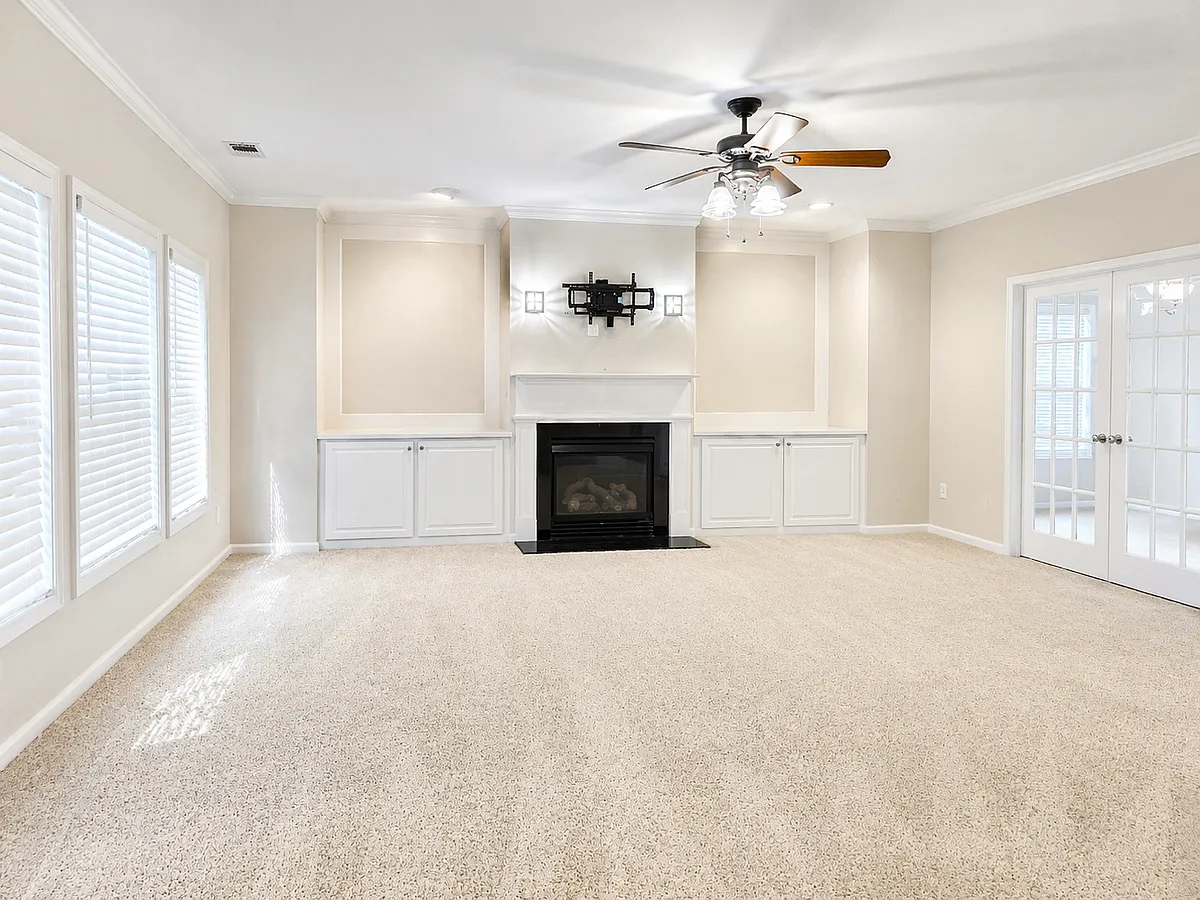 Spacious family room featuring custom built-in cabinets and a pre-installed TV mount, with elegant French doors leading to a private office space with surround sound connections available. A great place to watch movies or sports. - 2143 Somerset Pl SE