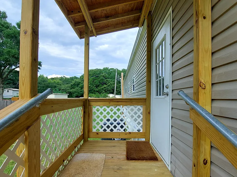 The stairs to the back door are covered and shallow - half of ADA allowance - with handrails on each side.