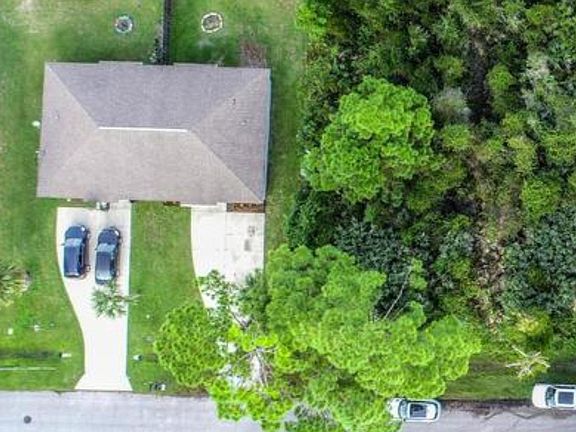 Aerial view before fence and includes double car driveway and metal roof