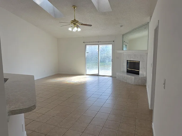 Great room and edge of breakfast bar, skylights and fireplace