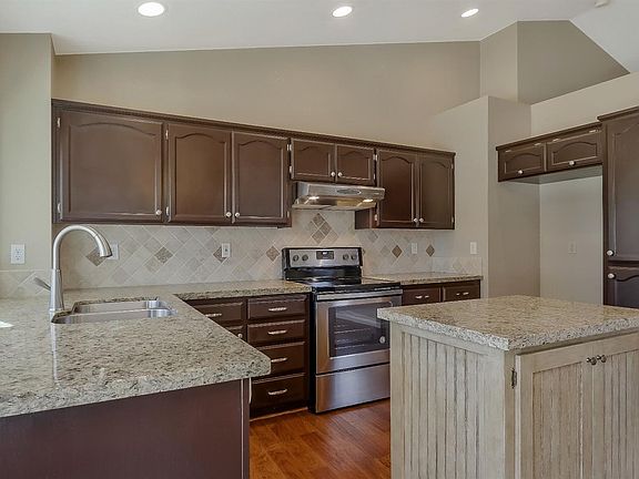 GORGEOUS kitchen with granite countertops, new oven/stove, and lovely backsplash tile.