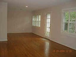 Plantation shutters filter the soft natural light as it shines on the gleaming hardwood floors.