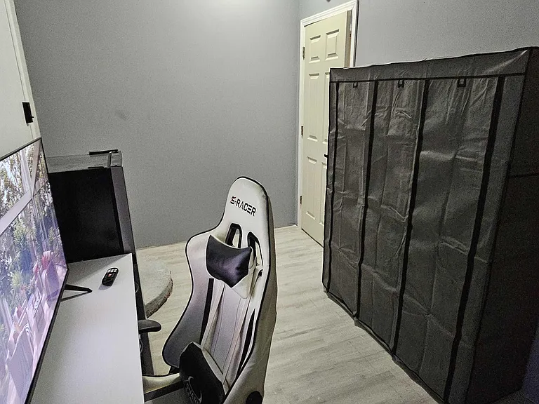 Multipurpose room with durable flooring, a work/study setup, and a large wardrobe for convenient storage.