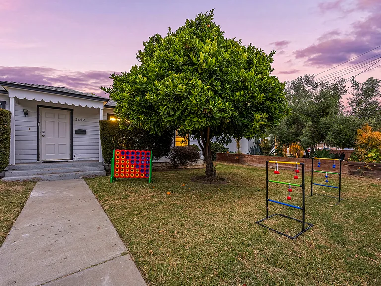 Spacious front yard with outdoor games, lush landscaping, and a beautiful orange tree where guests can pick fresh oranges. Includes tandem driveway parking for up to 3 cars.