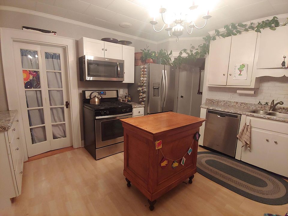 Kitchen, door on the left is the larger bedroom. Past the fridge is the bathroom.