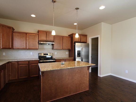 Spacious kitchen with SS appliances, island, granite countertops and large pantry.