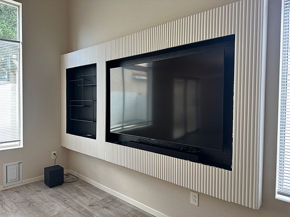 Wall unit includes shelving and LED lighting above and underneath for ambiance.