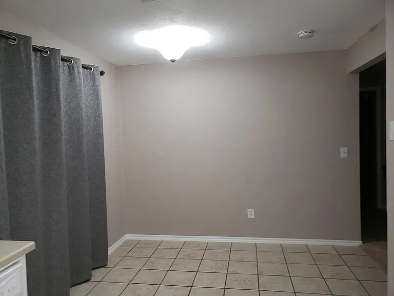Roomy dining room with new black out curtains for sliding glass door.