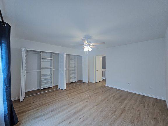 Master Bedroom Suite with spacious closets, fan, and blackout curtains