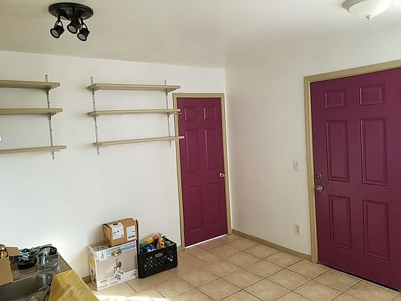 kitchen /living space . shelves and doors to room and outside.