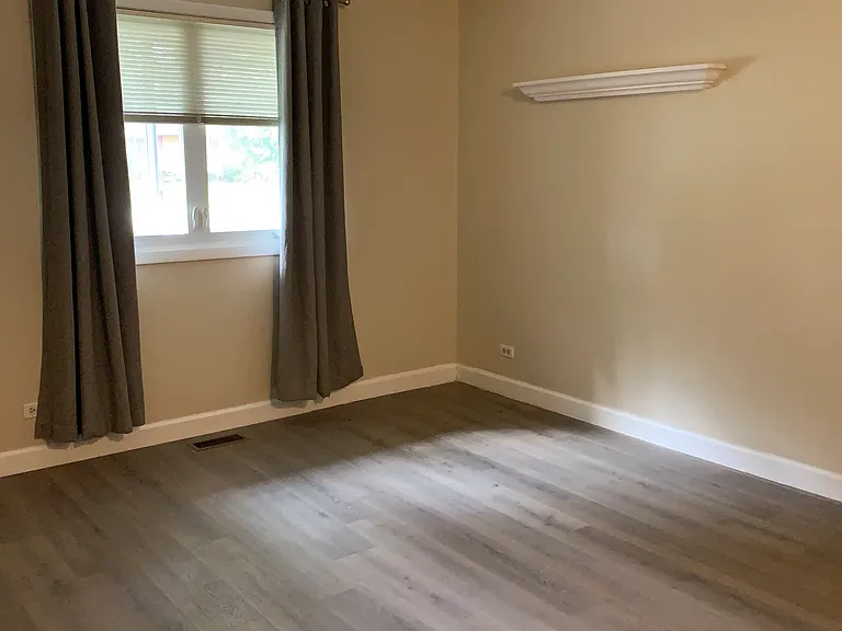 Large Bedroom w/ street view and a white floating shelf