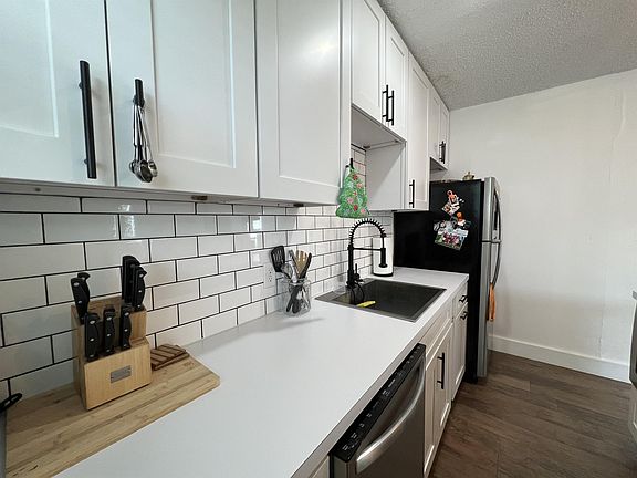 Has large countertop, white shaker cabinets with slow close doors & white subway tile backsplash