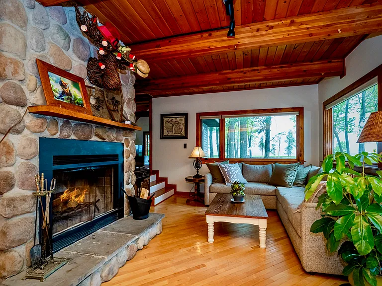 Warm, welcoming retreat with natural wood tones, a charming fireplace, and peaceful views bringing the outdoors in.