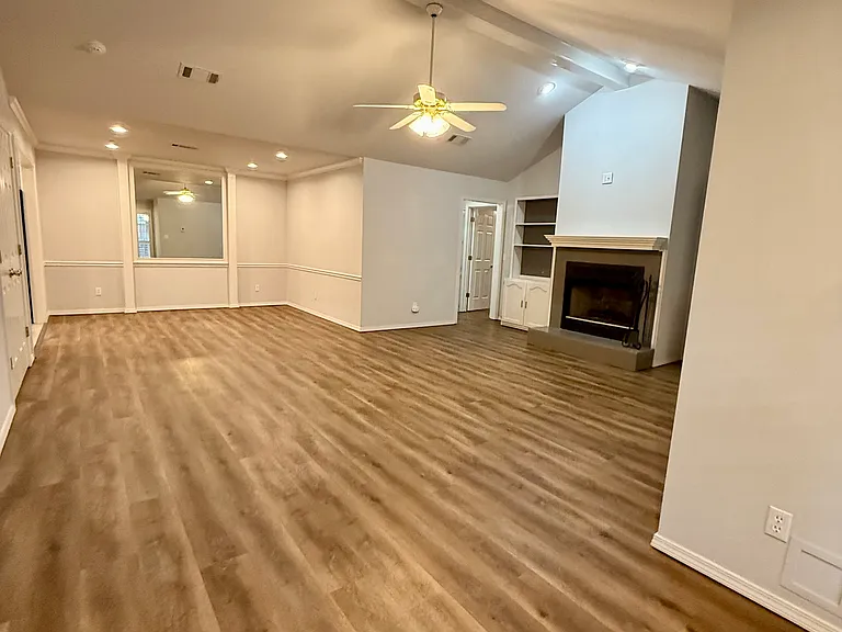 Open living room/dining room with vaulted ceilings and skylight.