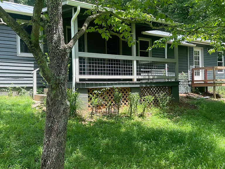 Charming, country cottage with front porch and lovely yard.