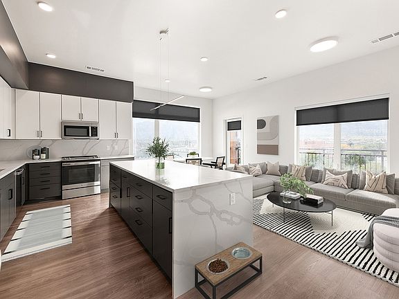 Modern open-concept kitchen and living area with sleek cabinetry, a spacious island, and panoramic window views.